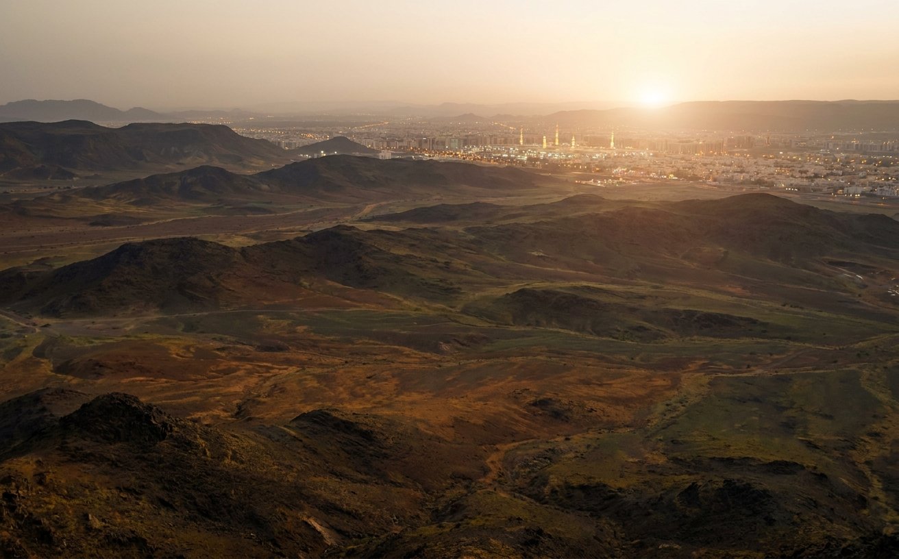 Dark volcanic rock field near Madinah glowing at sunset